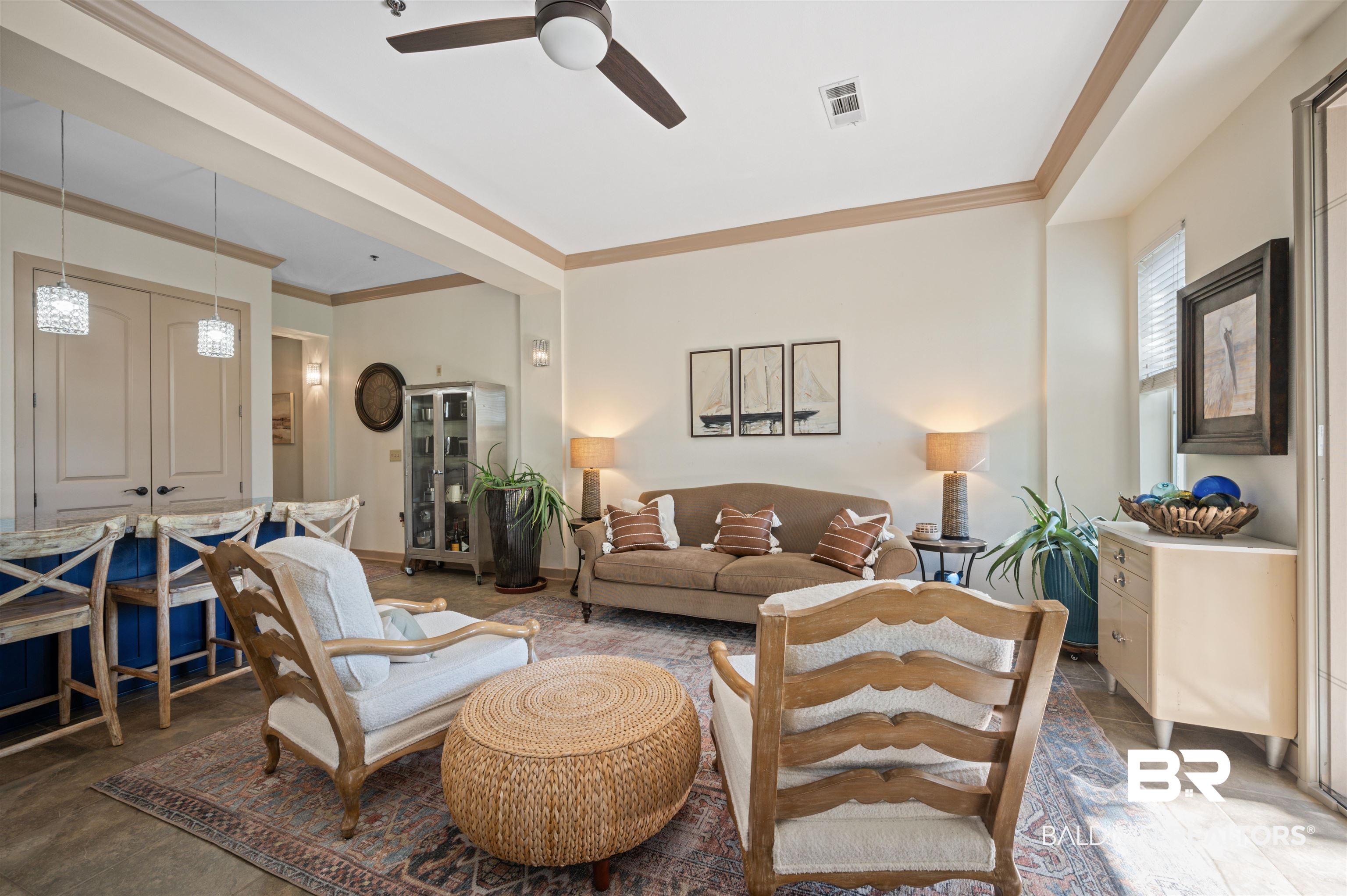 1430 Regency Road, Unit B202 Gulf Shores, AL 36542 - Photo 20 of 33 Living area featuring ceiling fan, ornamental molding, visible vents, and baseboards