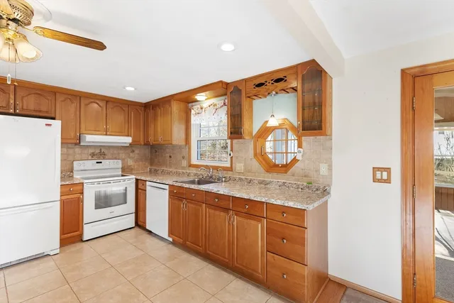 a kitchen with granite countertop white cabinets and white appliances