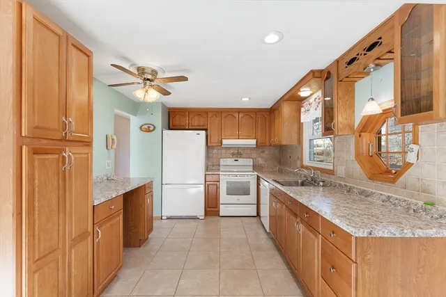 a large kitchen with stainless steel appliances granite countertop a stove and a refrigerator