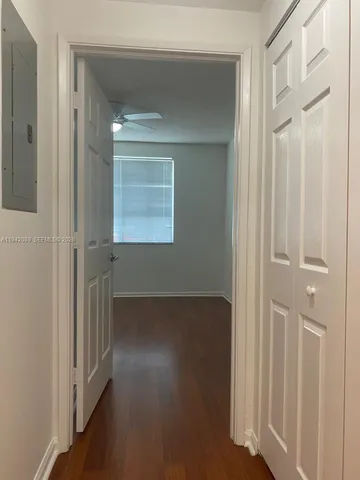 a view of a hallway with wooden floor and staircase