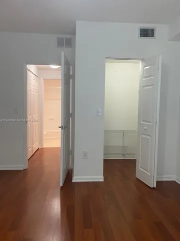 an empty room with wooden floor and closet