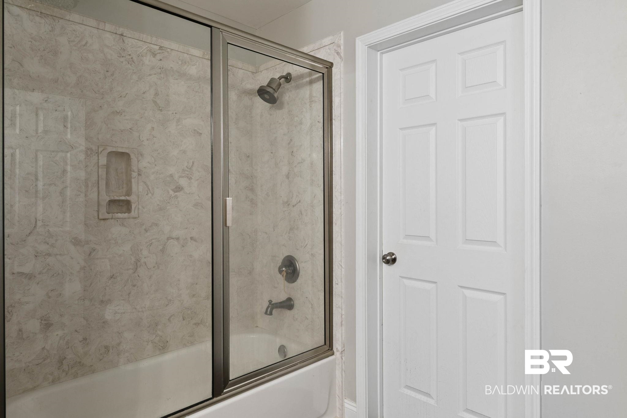 22810 High Ridge Road Fairhope, AL 36532 - Photo 38 of 78 Bathtub with stone-look surround, integrated shower niche, and glass sliding shower door