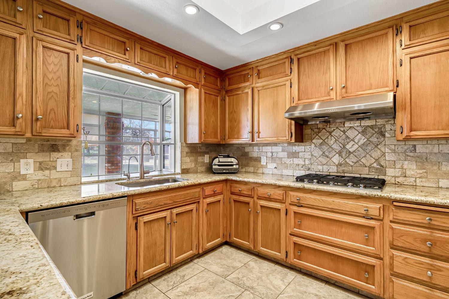 2436 Trevor Court Madera, CA 93637 - Photo 17 of 57 a kitchen with stainless steel appliances granite countertop a sink stove and cabinets