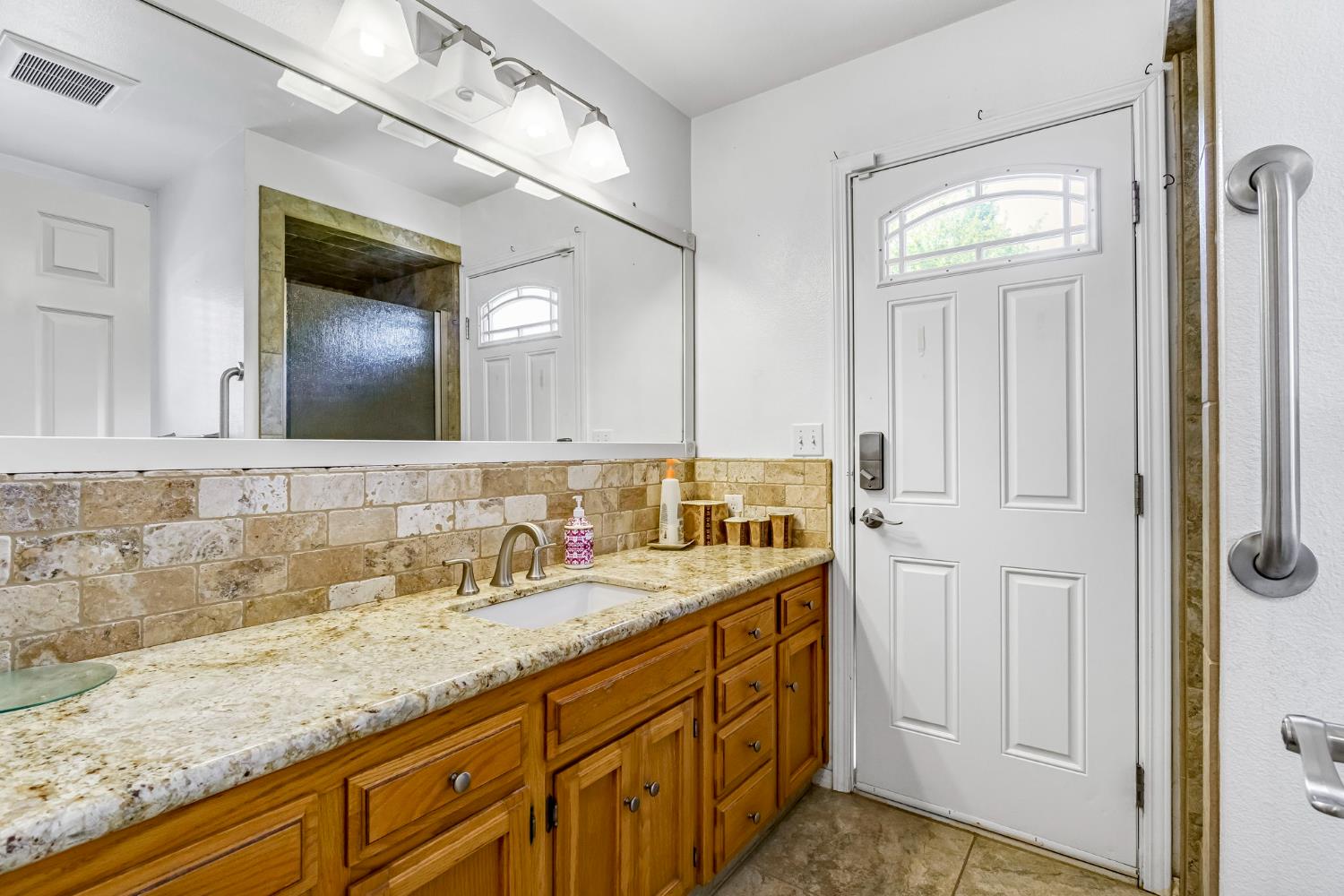 2436 Trevor Court Madera, CA 93637 - Photo 26 of 57 a bathroom with a granite countertop sink and a mirror