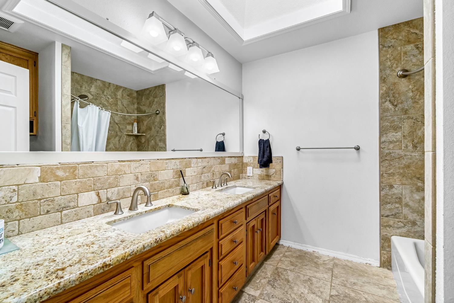 2436 Trevor Court Madera, CA 93637 - Photo 30 of 57 a bathroom with a granite countertop sink and a mirror