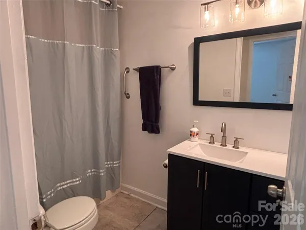 a bathroom with a sink vanity mirror and toilet