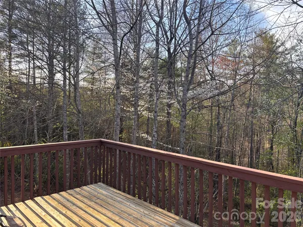 a wooden deck with trees in front of it