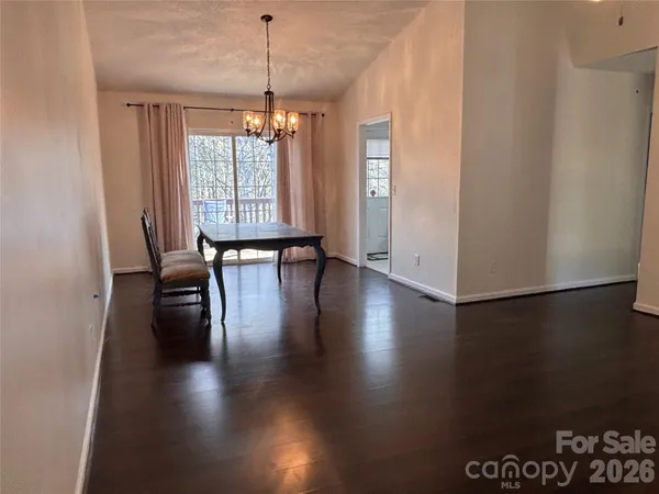 a hallway with wooden floor chandelier and entryway