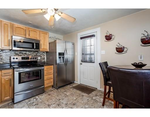 159 Powell Avenue Springfield, MA 01118 - Photo 10 of 30 a kitchen with stainless steel appliances granite countertop a stove a refrigerator a microwave oven with a dining table and chairs