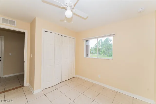 an empty room with windows and fan