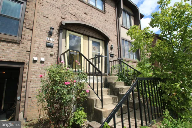a view of a house with brick walls and flower plants