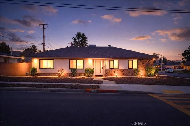 a front view of a house with a yard and mountain