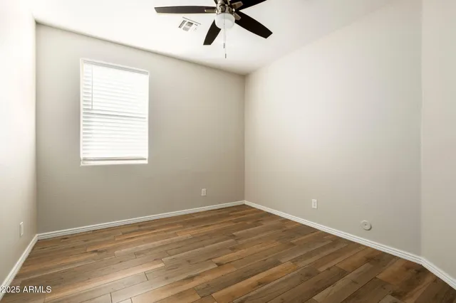 an empty room with a window and a fan