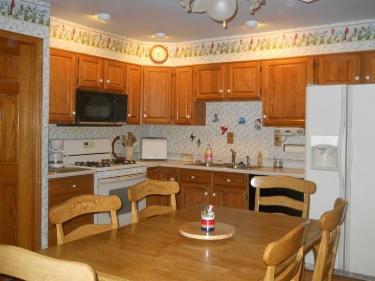 701-1 Fox River Road Valparaiso, IN 46385 - Photo 9 of 10 a kitchen with a sink a stove and chairs