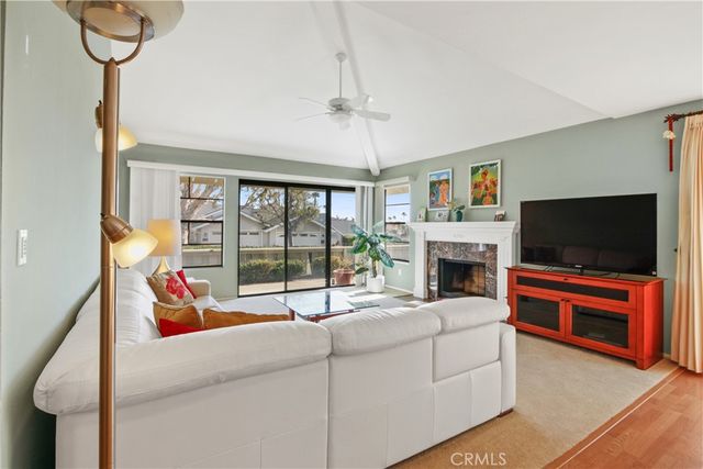 a living room with furniture a flat screen tv and a fireplace
