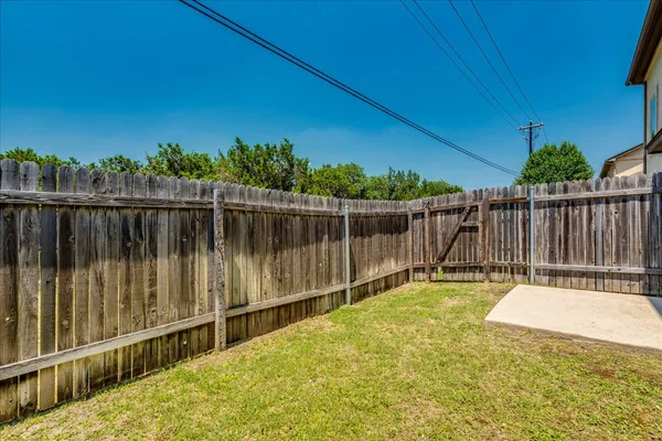 a view of a backyard with a wooden fence
