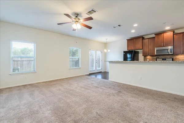 a view of an empty room with kitchen appliances and a window