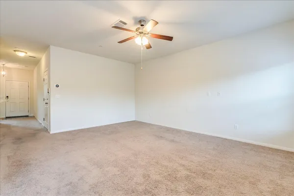 an empty room with closet and a ceiling fan