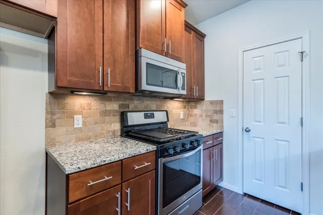 a kitchen with granite countertop cabinets stainless steel appliances and wooden cabinets