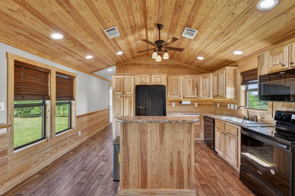 2401 Lamkin Road Mineral Wells, TX 76067 - Photo 11 of 36 a kitchen with stainless steel appliances kitchen island granite countertop a stove a sink and a refrigerator