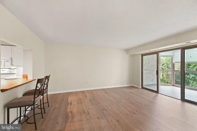 a view of a room with wooden floor and furniture