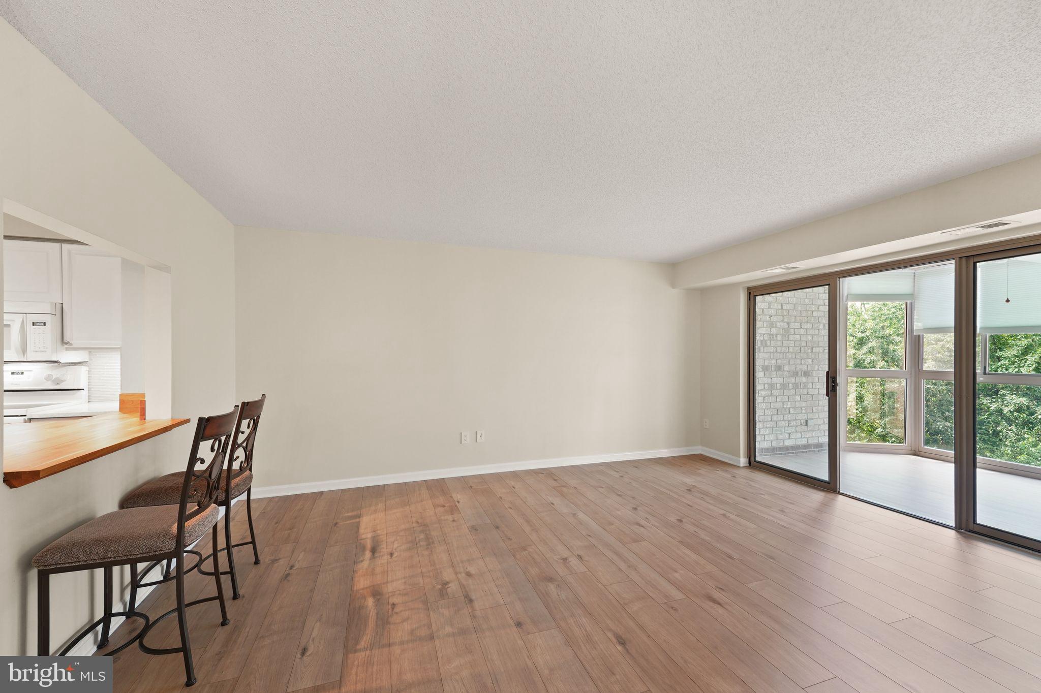 19385 Cypress Ridge Terrace, Unit 522 Leesburg, VA 20176 - Photo 11 of 33 a view of a room with wooden floor and furniture