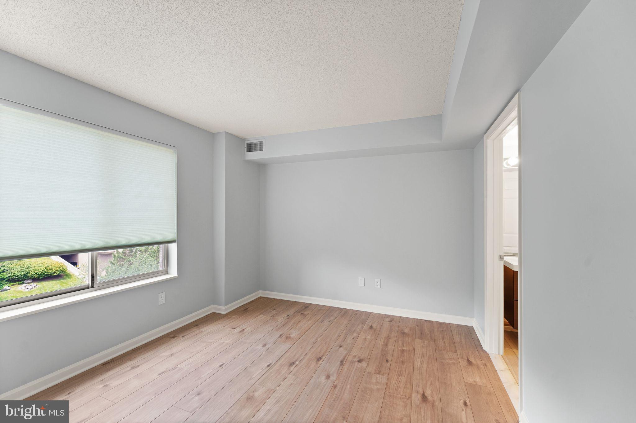 19385 Cypress Ridge Terrace, Unit 522 Leesburg, VA 20176 - Photo 17 of 33 a view of an empty room with wooden floor and a window