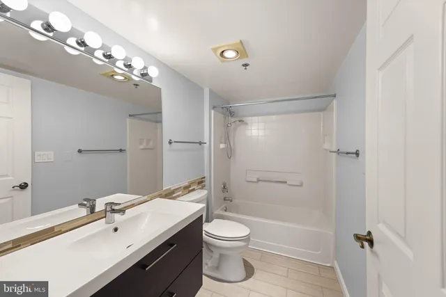 a bathroom with a toilet a sink a mirror and a bathtub