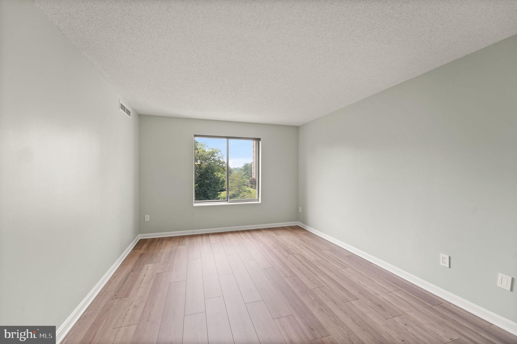 19385 Cypress Ridge Terrace, Unit 522 Leesburg, VA 20176 - Photo 23 of 33 a view of an empty room with wooden floor and a window