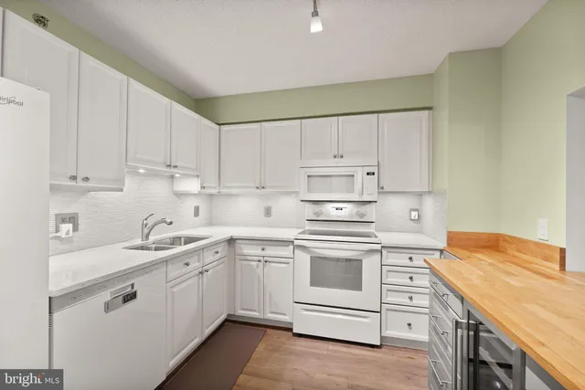 a kitchen with white cabinets sink and stove