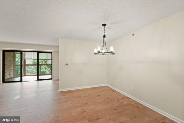 a view of empty room with wooden floor and window