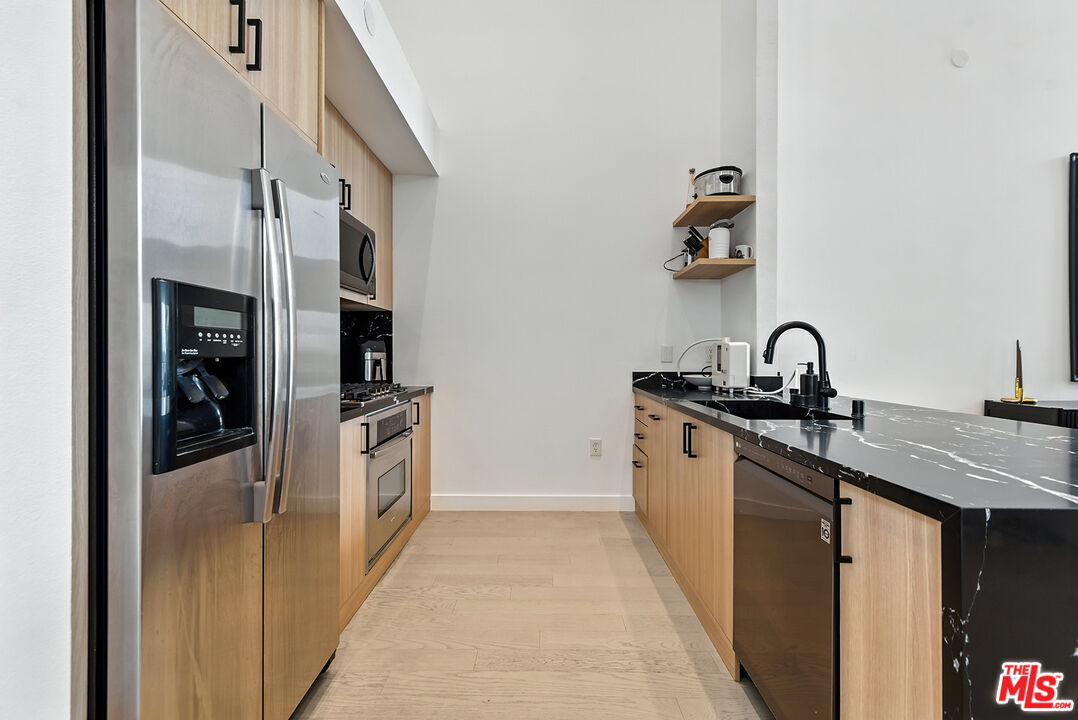 4211 Redwood Avenue, Unit 402 Los Angeles, CA 90066 - Photo 11 of 33 a kitchen with stainless steel appliances granite countertop a sink and cabinets
