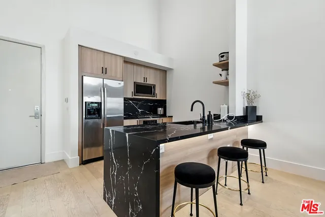 a kitchen with stainless steel appliances granite countertop a sink and a refrigerator