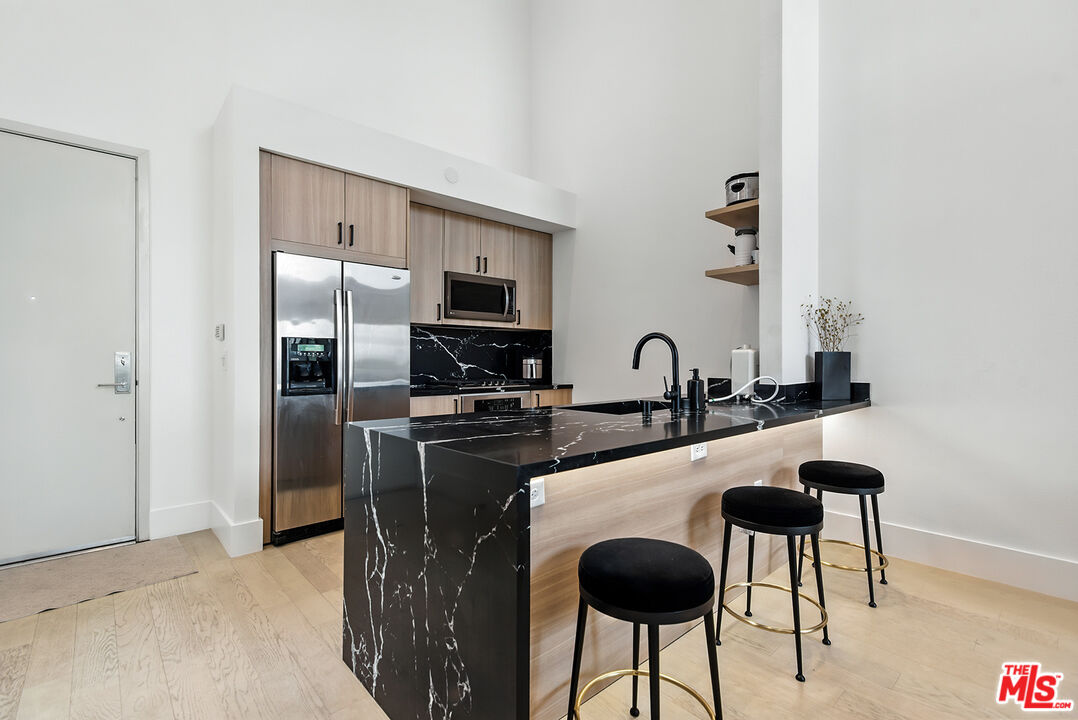 4211 Redwood Avenue, Unit 402 Los Angeles, CA 90066 - Photo 12 of 33 a kitchen with stainless steel appliances granite countertop a sink and a refrigerator