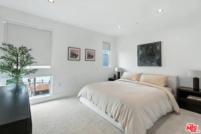 a bedroom with a bed and a potted plant