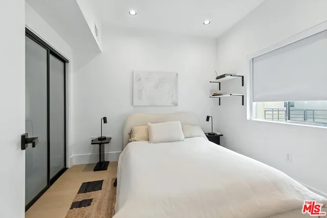 a bedroom with a bed and a large mirror