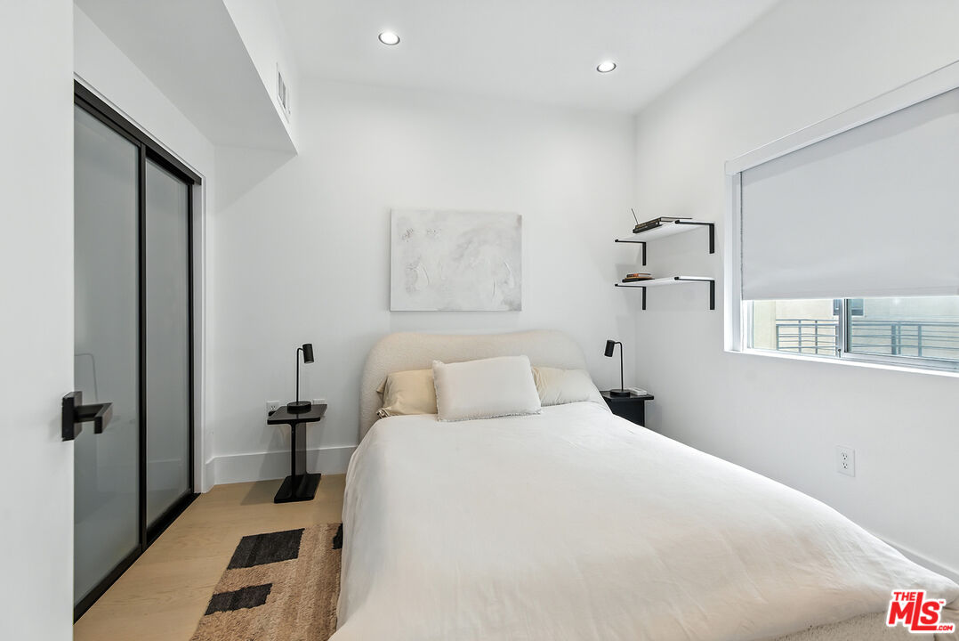 4211 Redwood Avenue, Unit 402 Los Angeles, CA 90066 - Photo 19 of 33 a bedroom with a bed and a large mirror