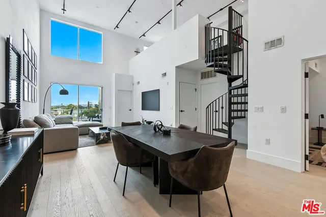 a living room with dining table and wooden floor