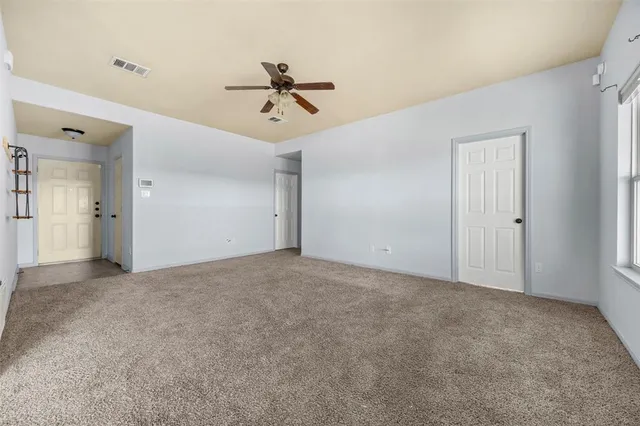 a view of a livingroom with a ceiling fan and window