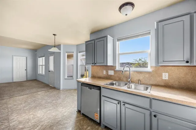 a kitchen with a sink refrigerator and cabinets