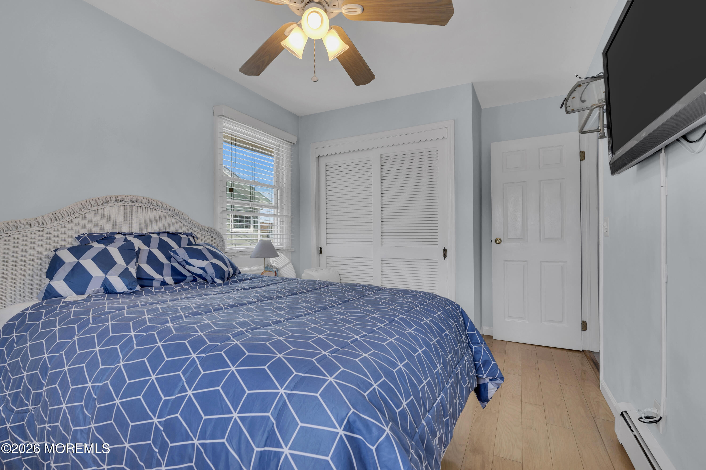 8 President Avenue, Unit 1 Lavallette, NJ 08735 - Photo 12 of 18 a bedroom with a bed and a chandelier