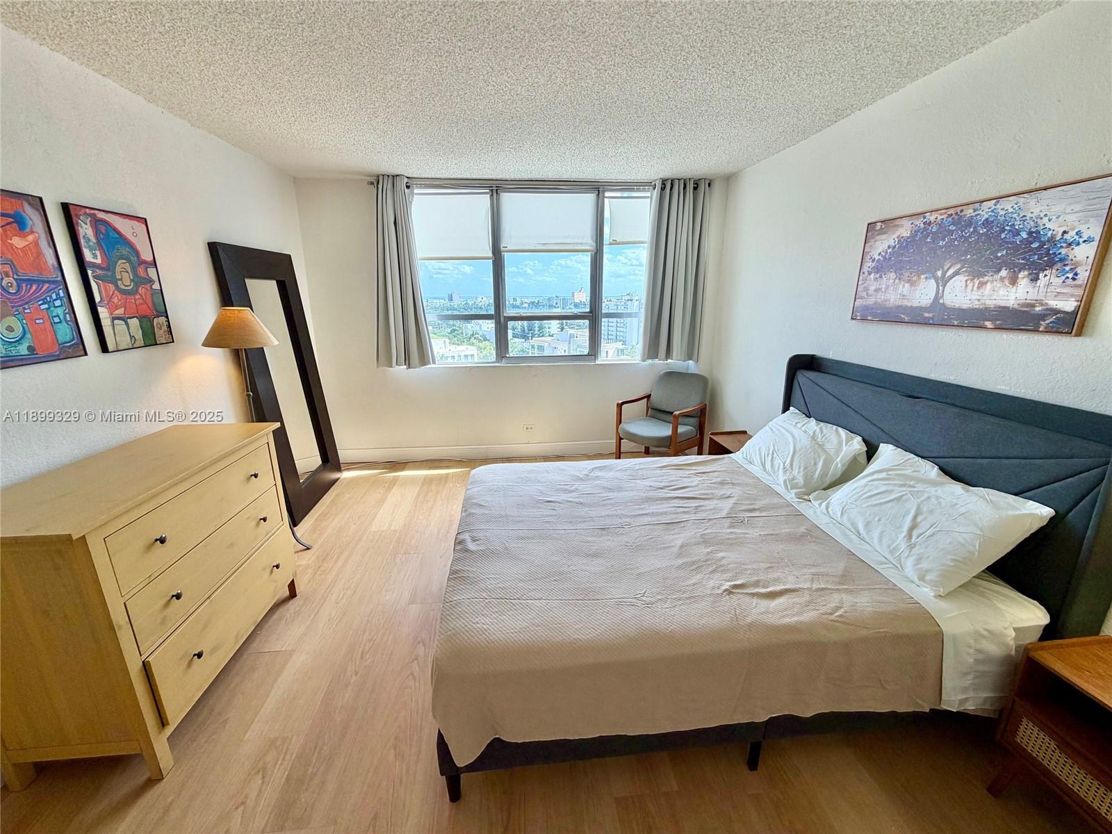 1500 Bay Road, Unit 1274S Miami Beach, FL 33139 - Photo 12 of 36 a bedroom with a large bed and a flat tv screen on the dresser