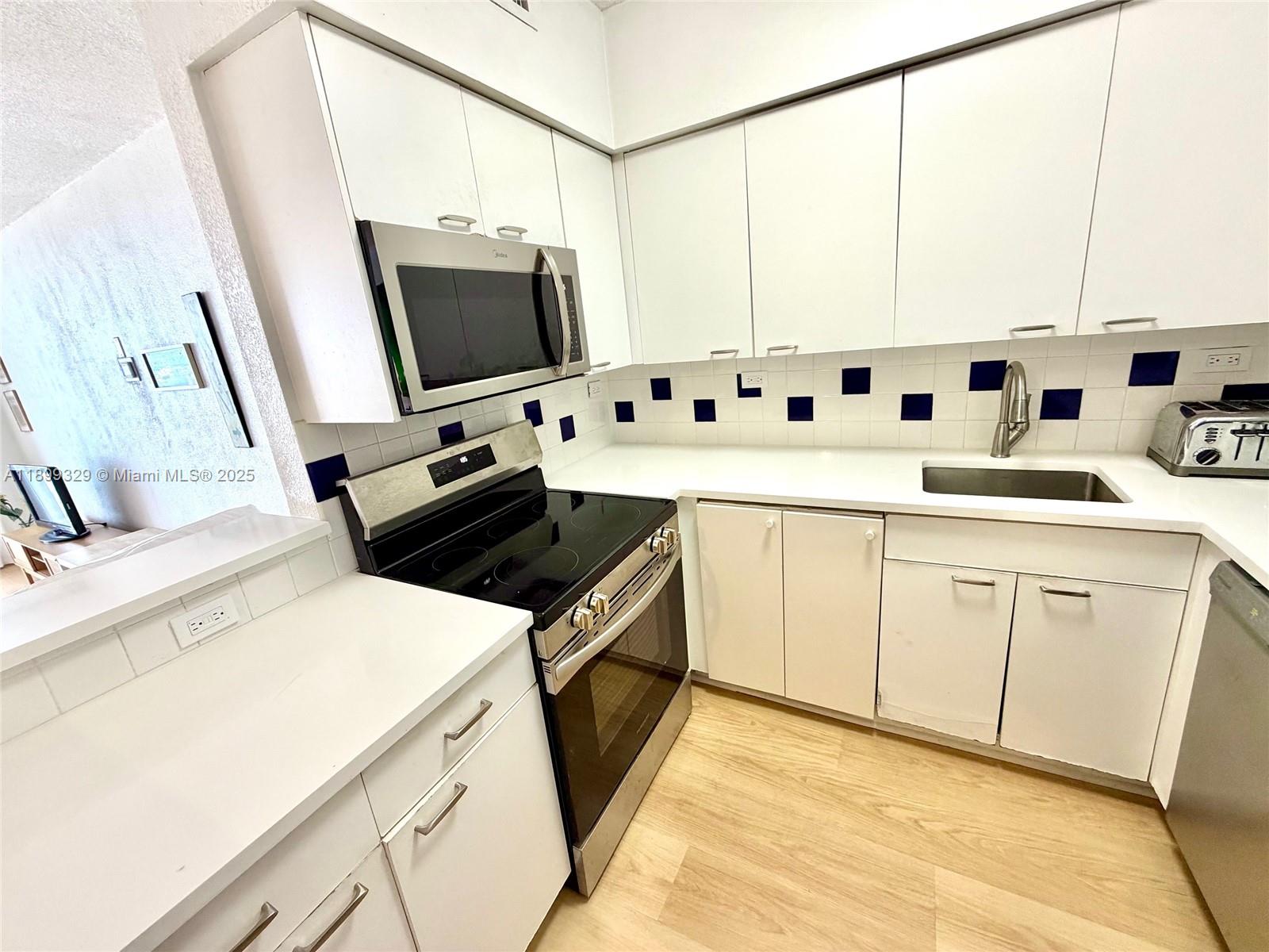1500 Bay Road, Unit 1274S Miami Beach, FL 33139 - Photo 10 of 36 a kitchen with stainless steel appliances a stove a sink and a refrigerator
