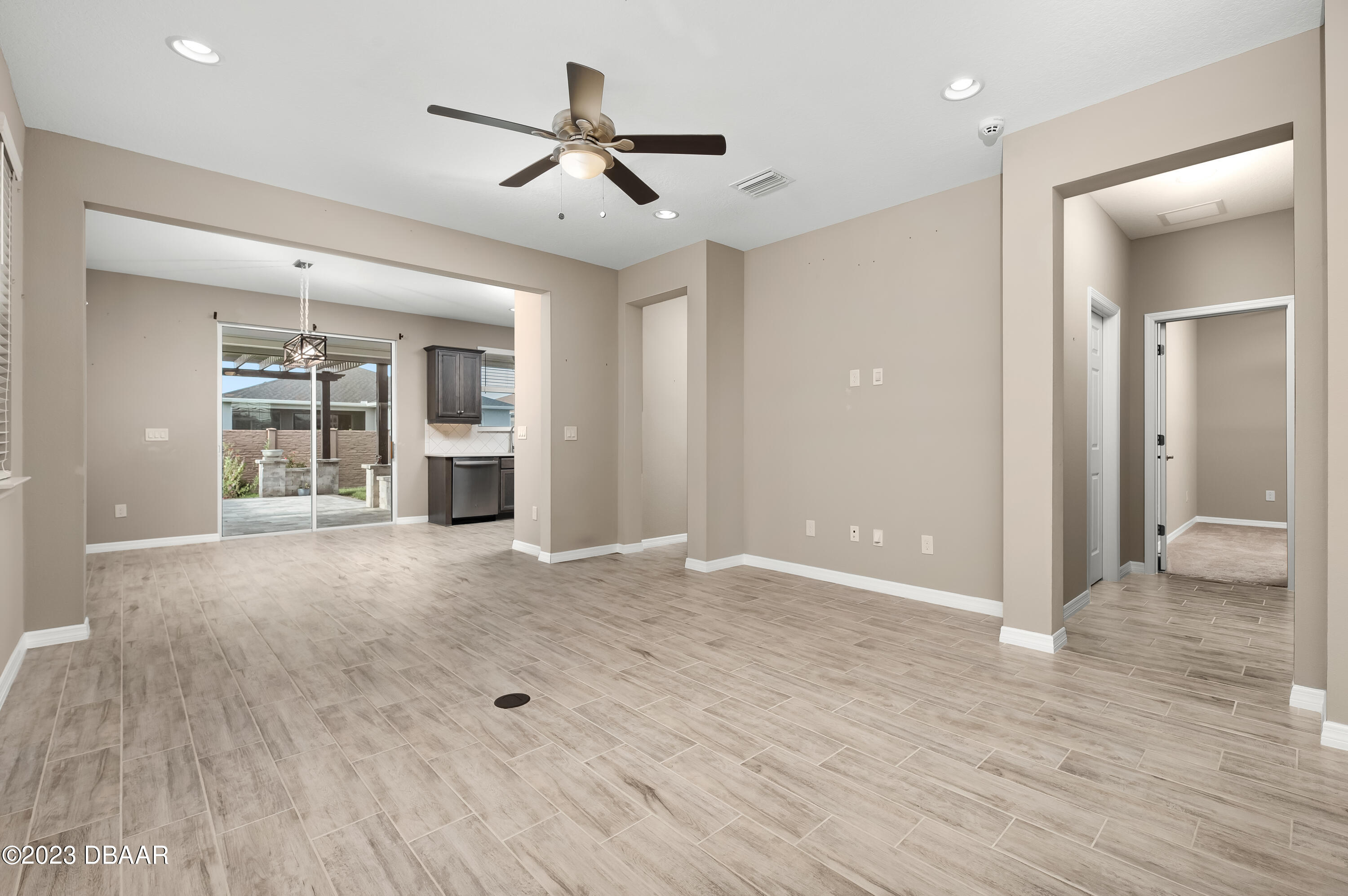 5658 Northwest 40th Loop Ocala, FL 34482 - Photo 14 of 80 a view of an empty room with wooden floor and a ceiling fan