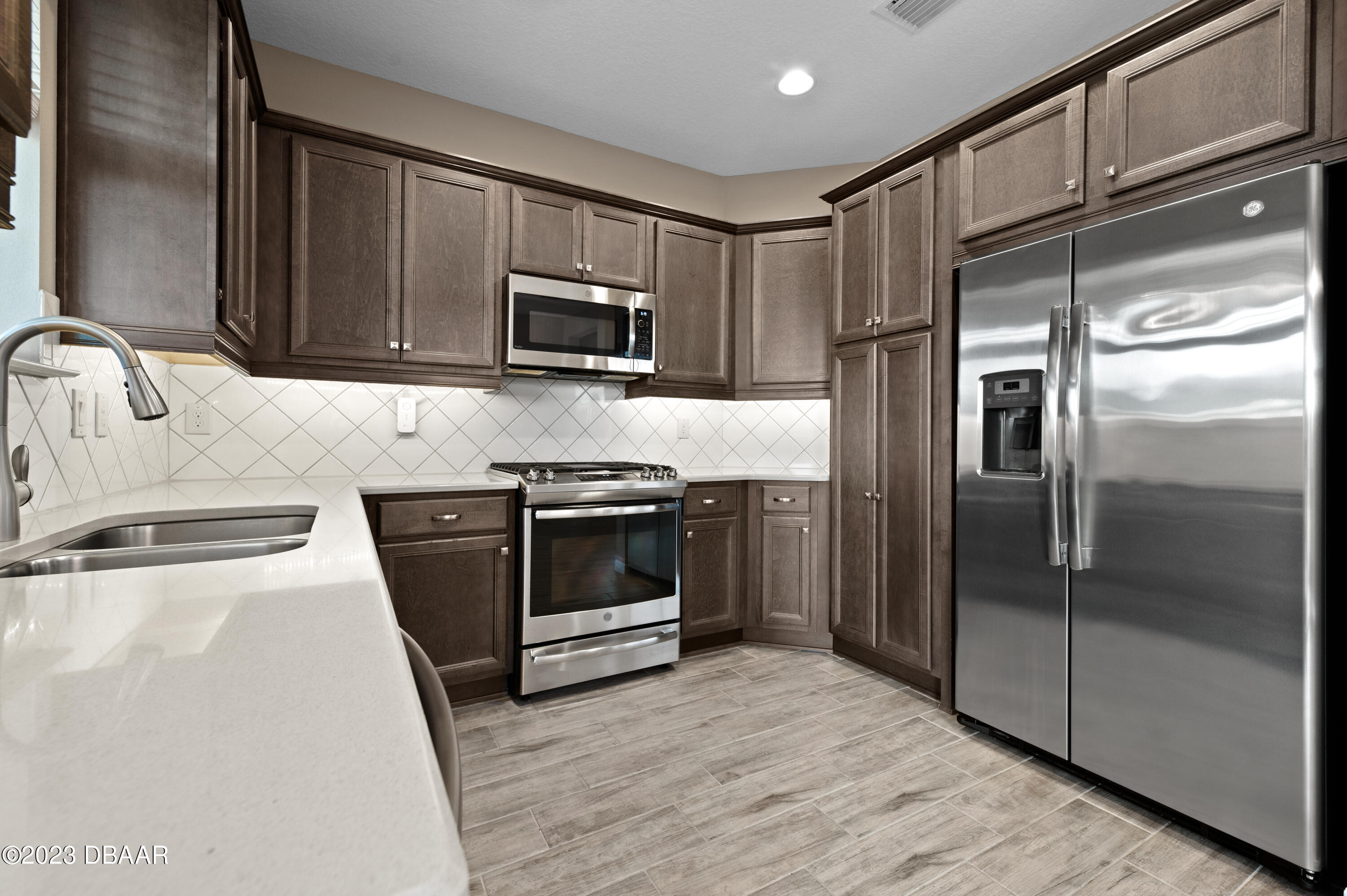 5658 Northwest 40th Loop Ocala, FL 34482 - Photo 25 of 80 a kitchen with granite countertop a refrigerator stove and microwave