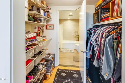 a view of walk in closet with clothes and shoes