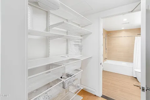 a view of an empty walk in closet with wooden floor
