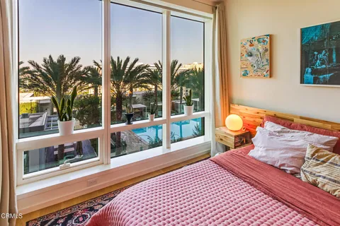 a bedroom with furniture and a large window