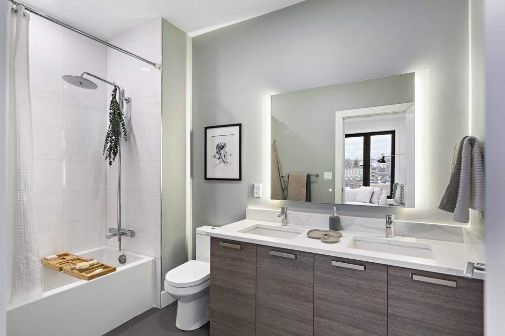 30 Penniman Road, Unit 307 Boston, MA 02134 - Photo 5 of 10 a bathroom with a double vanity sink toilet and a mirror