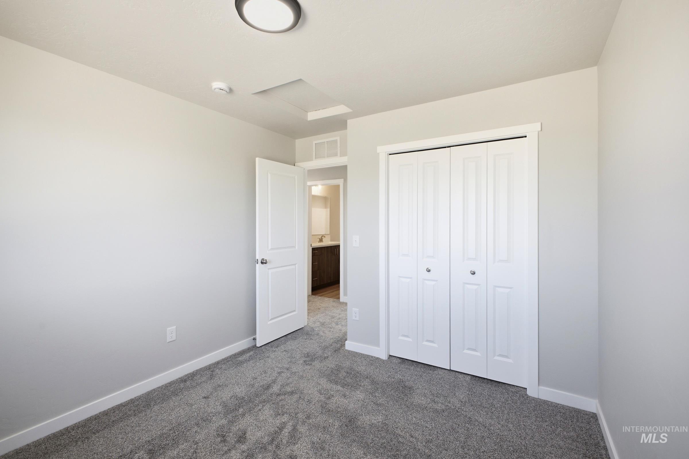 13325 Scrape Street Caldwell, ID 83607 - Photo 18 of 24 Plush gray carpeting, white bi-fold closet doors, and light gray wall paint